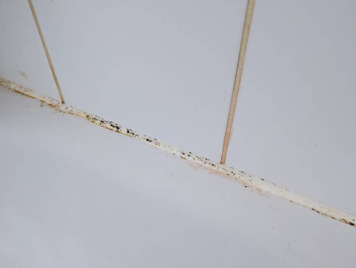 Mouldy caulk replaced, before